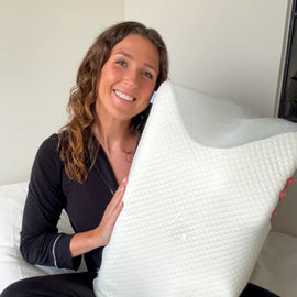 Client satisfait tenant l’oreiller Novéa